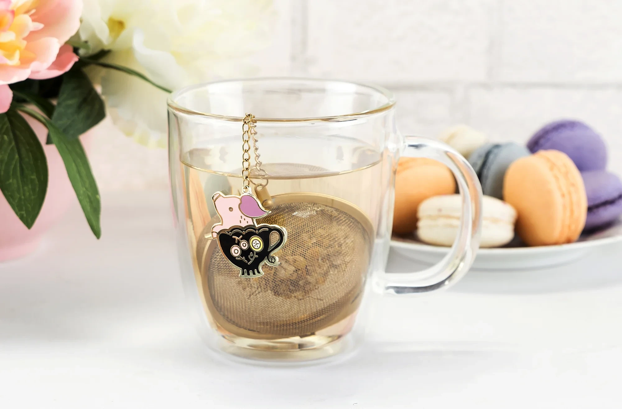 Some illustrations were turned into metal enamel charms. They functioned as weights to prevent the chain on the mesh ball from falling into your mug.
